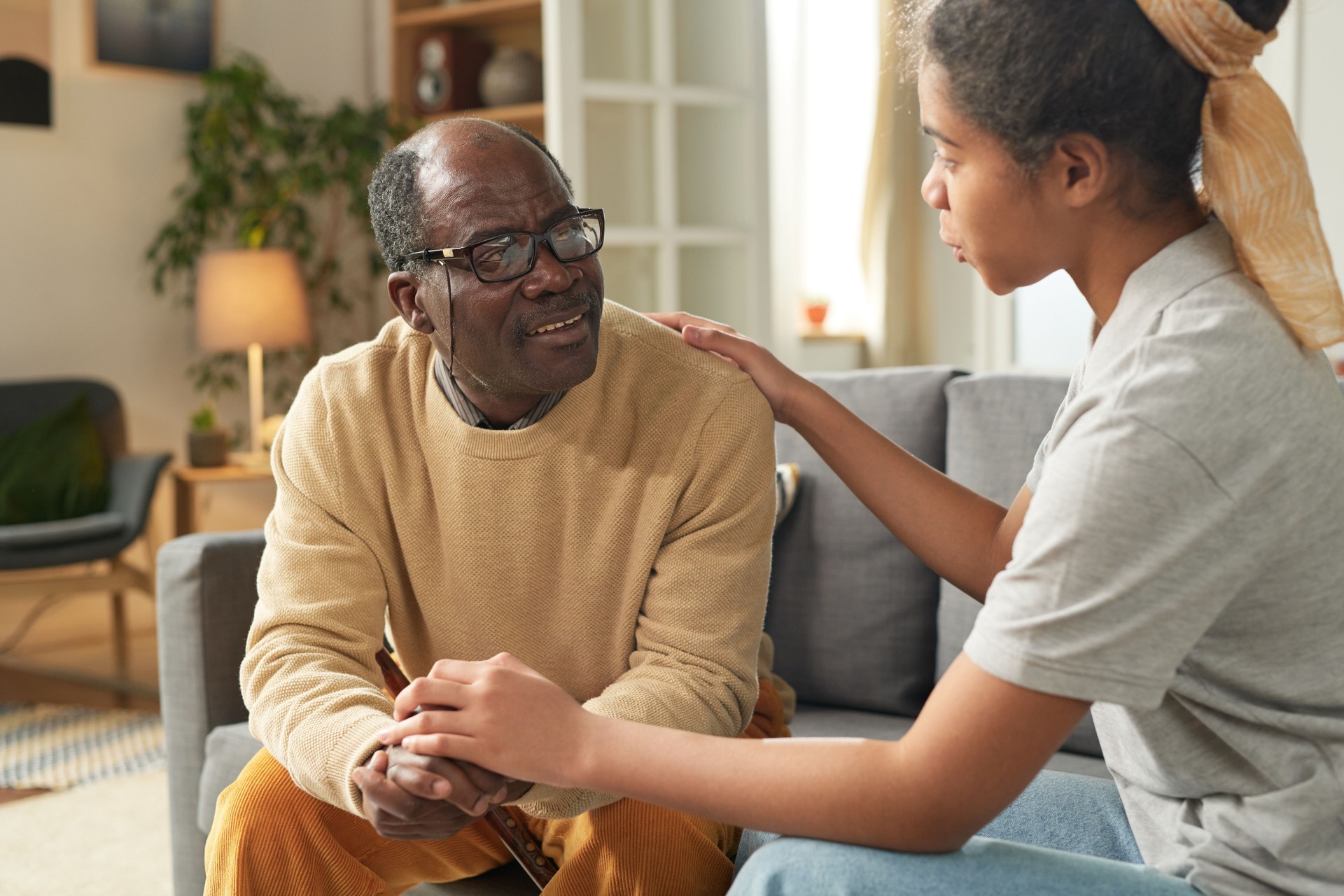 Elderly Man Interacting with African American Girl Offering Comfort